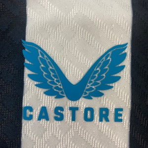 May include: A white and black striped athletic jersey with a blue winged logo and the word "CASTORE" printed on the front.