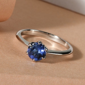 Può includere: Un anello d'argento con una pietra preziosa blu incastonata a griffe.