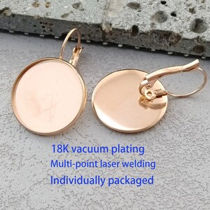 May include: A pair of gold-tone earring blanks with a round, flat surface. The earrings are made with a hook closure and are ready to be customised with your own designs.
