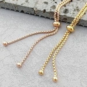 May include: Two gold chain bracelets with adjustable sliding knots. One bracelet is rose gold and the other is yellow gold.