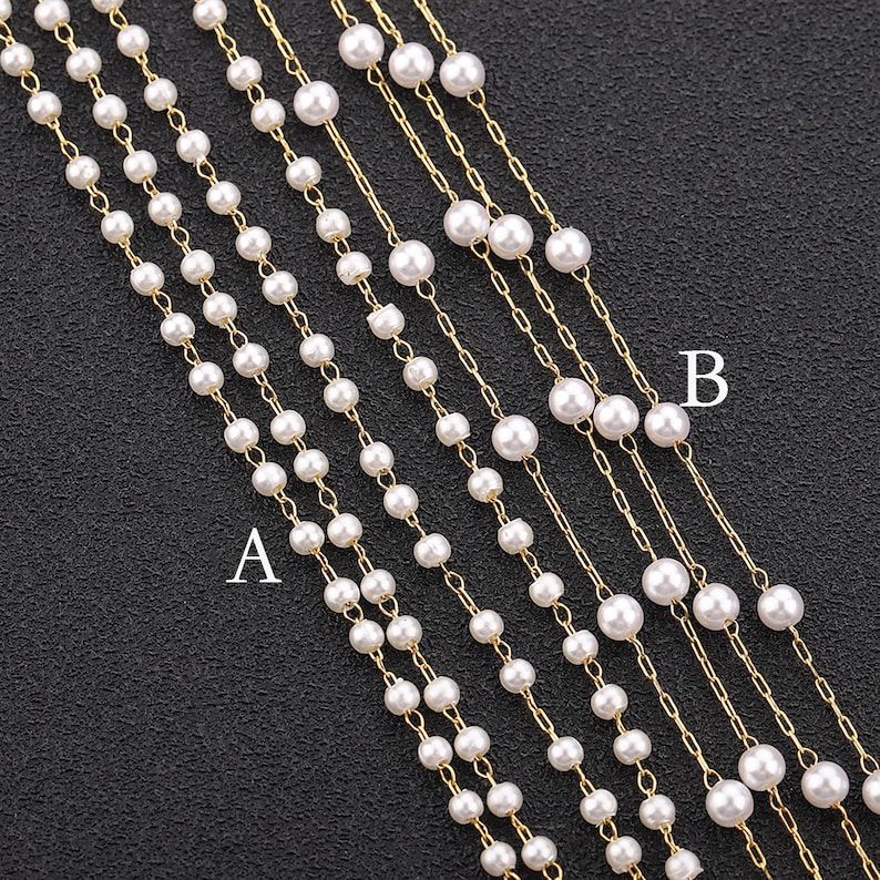 May include: Six strands of gold chain necklaces with white pearl beads. The necklaces are arranged in a fan shape, with the top strand being the shortest and the bottom strand being the longest. The necklaces are labelled "A" and "B".