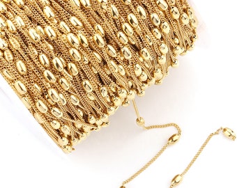 May include: A spool of gold-colored chain with oval-shaped beads. The chain is made of metal and is perfect for jewelry making.