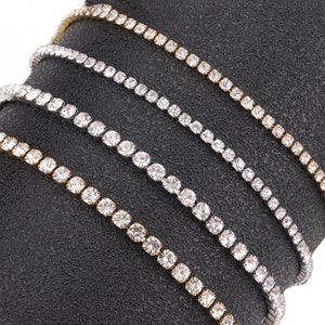 Puede incluir: Cuatro cadenas de diferentes longitudes en plata y oro con diamantes de imitación transparentes.
