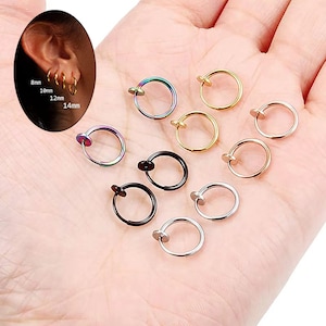 以下が含まれることがあります： シルバー、ゴールド、ブラック、レインボーなど、さまざまなサイズと色のステンレス製のノーズリング10個セット。リングの直径は8mm、10mm、12mm、14mmです。