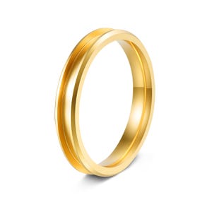 May include: A gold ring with a distinctive design. The ring has a grooved centre, giving it a double-band look. The polished surface reflects light, emphasising the smooth texture. This piece of jewellery is suitable for everyday wear.