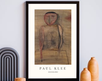 May include: A black framed poster with a painting of a person with a red face and a brown body. The painting is by Paul Klee and is titled "Doctor" (1920).