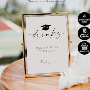 May include: A framed sign with the word "drinks" in elegant script, topped with a graduation cap illustration. The sign reads "Please help yourself!" and "thank you!" in a gold frame, on a wooden tray.