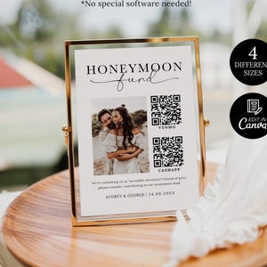 May include: A white rectangular sign in a gold metal frame featuring the text HONEYMOON fund, a photograph of a couple, two QR codes labeled VENMO and CASHAPP, and the text AUDREY & GEORGE | 24.08.20XX. The sign includes text about a honeymoon fund.