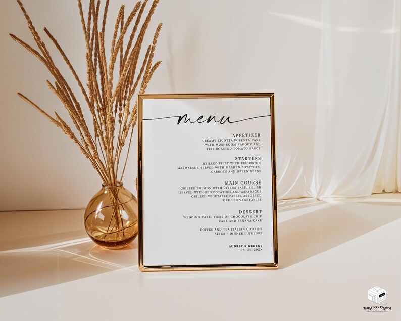 Op de afbeelding: Een goudomrand menu met sierlijk handschrift, met gerechten zoals voorgerechten en desserts. Links staat een vaas met gedroogde tarwestengels. Het menu staat op een wit oppervlak.