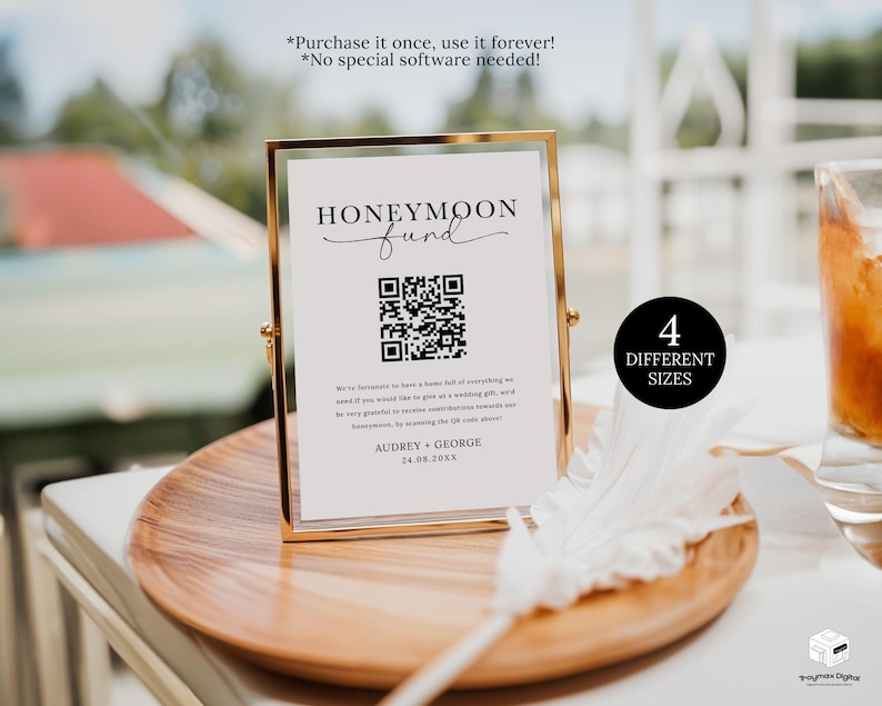 May include: A white sign with black text and a QR code in a gold frame. The sign reads 'Honeymoon fund' and has the names 'Audrey + George' and the date '24.08.20XX'. The sign is sitting on a wooden surface with a white feather and a glass of brown liquid in the background. The text '4 Different Sizes' is in a black circle on the right side of the image.