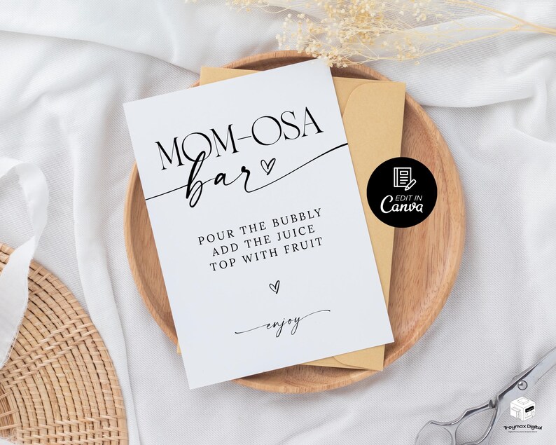 May include: Printable sign for a "Mom-osa Bar" with instructions to "Pour the bubbly, add the juice, top with fruit" and the word "enjoy" in cursive. The sign is on a wooden surface with a brown envelope and a white background.