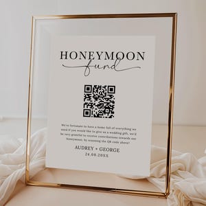 Puede incluir: Un cartel blanco con marco dorado, que dice "Honeymoon Fund" con un c&oacute;digo QR y el texto "We're fortunate to have a home full of everything we need if you would like to give us a wedding gift, we'd be very grateful to receive contributions towards our honeymoon, by scanning the QR code above! Audrey + George 24.08.20XX"