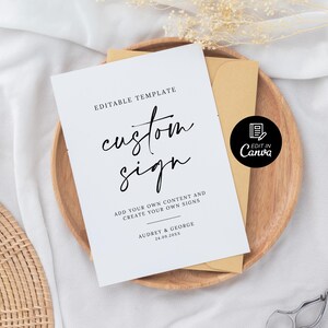 May include: Editable template for a custom sign with the text "custom sign" in black script font. The text "Add your own content and create your own signs" is below the title. The text "Audrey & George 24.09.20XX" is at the bottom of the sign. A black and white icon with the text "Edit in Canva" is in the upper right corner of the sign.