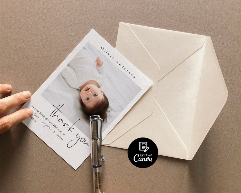 May include: A white thank you card with black calligraphy that reads "thank you" and "for your lovely gifts and kind wishes". The card features a photo of a baby lying on its back with its arms outstretched. The text "Olivia Anderson" is printed in the top right corner of the card.
