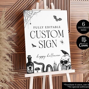 May include: A black and white Halloween-themed sign on a white easel. The sign features a spiderweb, bat, spider, skull, snake, and other spooky illustrations. Text includes "CUSTOM SIGN" and "happy halloween".