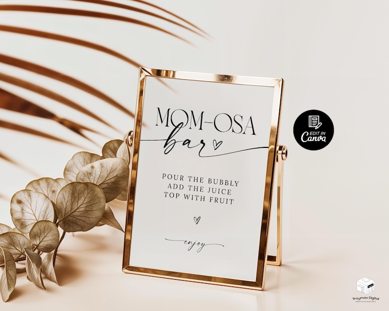 May include: A gold-framed sign with the text "MOM-OSA bar" in black cursive font. The sign also includes the instructions "POUR THE BUBBLY ADD THE JUICE TOP WITH FRUIT" and the word "enjoy" in a smaller font.