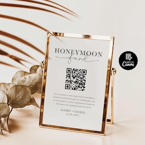 Puede incluir: Una tarjeta blanca con un marco dorado, un c&oacute;digo QR en blanco y negro y el texto "HONEYMOON fund" en escritura cursiva negra. El texto "We're fortunate to have a home full of everything we need, if you would like to give us a wedding gift, we'd be very grateful to receive contributions towards our honeymoon, by scanning the QR code above!" est&aacute; impreso debajo del c&oacute;digo QR. El texto "AUDREY GEORGE 24.08.20XX" est&aacute; impreso en la parte inferior de la tarjeta. La tarjeta est&aacute; colocada sobre un soporte dorado.
