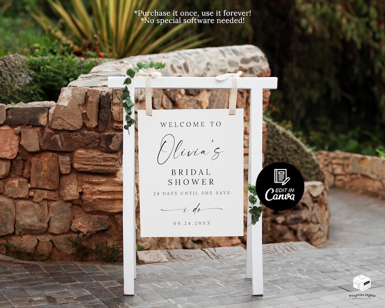Puede incluir: Un letrero blanco con el texto "WELCOME TO Olivia's BRIDAL SHOWER 24 DAYS UNTIL SHE SAYS I do 09.24.20XX". El letrero est&aacute; sostenido por un marco de madera blanco y decorado con vegetaci&oacute;n, sobre un muro de piedra.