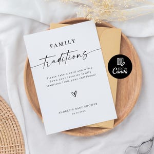 May include: A white card with black text that reads "FAMILY traditions" and "Please take a card and write down your favorite family tradition from your childhood!"  The card also includes the text "AUDREY'S BABY SHOWER 09.24.20XX" and a small heart. There is a black and white icon that says "EDIT IN Canva".