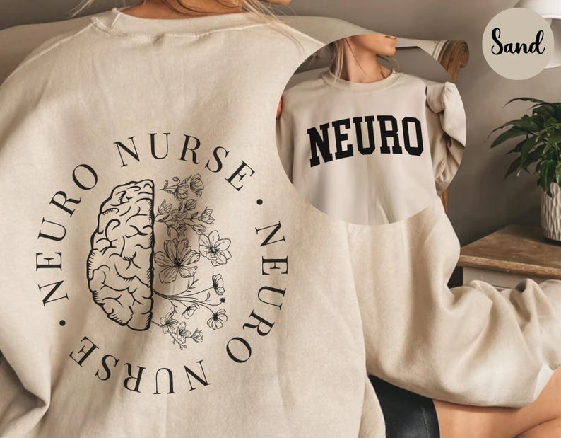 K&ouml;nnte beinhalten: Sandfarbenes Sweatshirt mit dem Wort "NEURO" in fetten schwarzen Buchstaben. Auf der R&uuml;ckseite des Sweatshirts befindet sich ein kreisf&ouml;rmiges Design mit den Worten "NEURO NURSE NEURO" um eine Gehirngrafik, von der die H&auml;lfte mit floralen Elementen verziert ist.