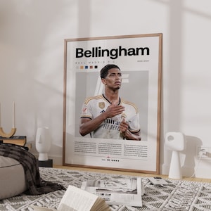 May include: A poster featuring a photo of Jude Bellingham, a soccer player for Real Madrid. The poster has a white background with the text "Bellingham" in black at the top and "REAL MADRID F.C." in smaller black text below. The poster also includes the text "2023-2024" in the top right corner.