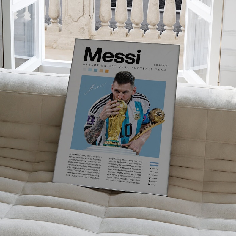 May include: A poster featuring a photo of Lionel Messi holding the World Cup trophy. The poster has a blue background with the text "Messi" in bold white letters and "Argentina National Football Team 2008-2023" in smaller white letters. The poster also includes a list of Argentina's World Cup wins.