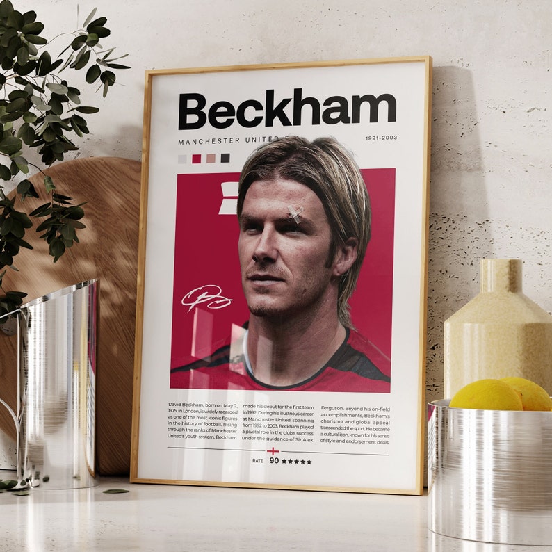May include: A red and white poster featuring a photo of David Beckham, a former professional footballer. The poster has the text "Beckham" in large black letters and "Manchester United" in smaller black letters. The poster also has the text "1991-2003" in smaller black letters. The poster has a rating of 90 stars.