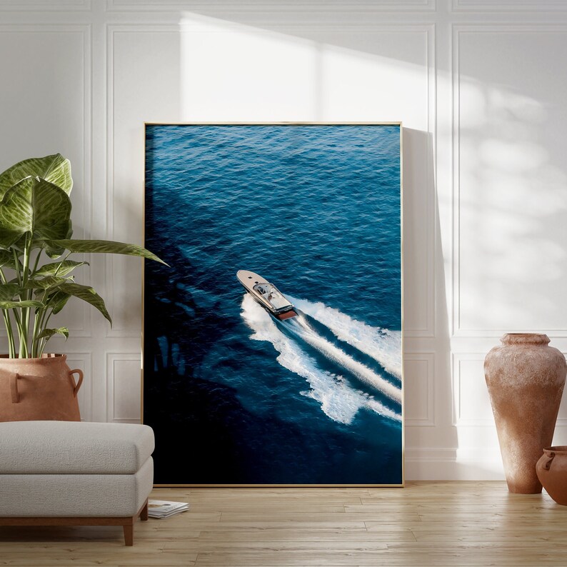 K&ouml;nnte beinhalten: Ein wei&szlig;es Schnellboot mit einem dunkelblauen Streifen f&auml;hrt durch das tiefblaue Meerwasser und hinterl&auml;sst eine wei&szlig;e Spur.