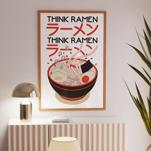 Puede incluir: Una impresi&oacute;n enmarcada con fondo blanco y una ilustraci&oacute;n en negro y rojo de un cuenco de fideos ramen. El texto "Think Ramen" est&aacute; escrito en letras negras sobre el cuenco y en caracteres japoneses debajo del cuenco.