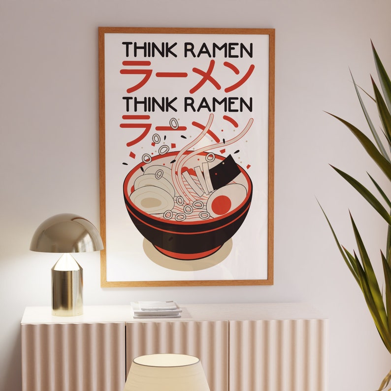 Puede incluir: Una impresi&oacute;n enmarcada con fondo blanco y una ilustraci&oacute;n en negro y rojo de un cuenco de fideos ramen. El texto "Think Ramen" est&aacute; escrito en letras negras sobre el cuenco y en caracteres japoneses debajo del cuenco.