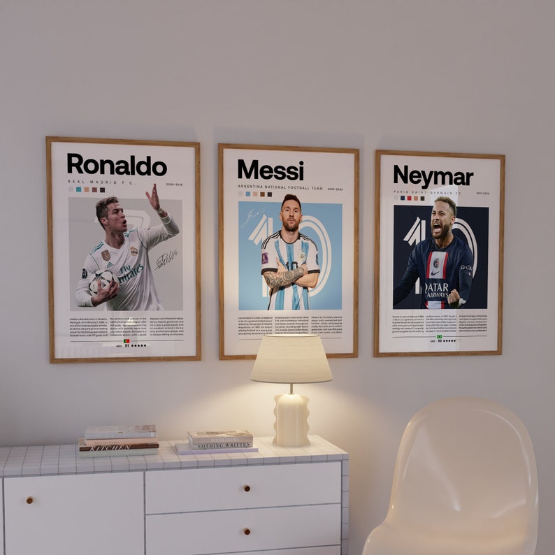May include: Three framed posters of famous soccer players, Ronaldo, Messi, and Neymar. Each poster features a photo of the player in their team uniform, with their name and team information printed below the photo.