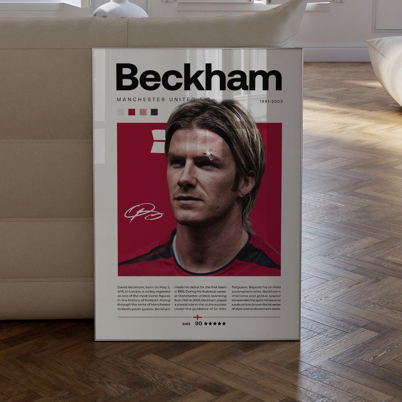 May include: A red and white poster featuring a photo of David Beckham, a former professional footballer. The poster has the text "Beckham" in large black letters, "Manchester United" in smaller black letters, and "1991-2003" in even smaller black letters. The poster also has a rating of "90*****".