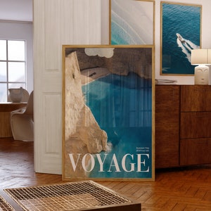 K&ouml;nnte beinhalten: Ein gerahmtes Poster mit einem Foto einer blauen Bucht mit einer felsigen Klippe. Das Poster hat das Wort "VOYAGE" in wei&szlig;en Buchstaben unten und den Text "Summer Trip 2022 July Chris" in kleineren Buchstaben.