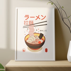 Puede incluir: Un p&oacute;ster enmarcado blanco con una ilustraci&oacute;n roja y blanca de un taz&oacute;n de fideos ramen. El texto en el p&oacute;ster dice "Ramen", "拉麺" y "美味しい！".