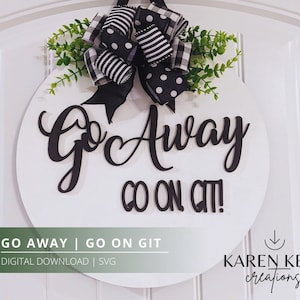May include: A white round wooden door hanger with black lettering that reads "Go Away Go On Git!"  The door hanger is decorated with a black and white bow and green leaves.