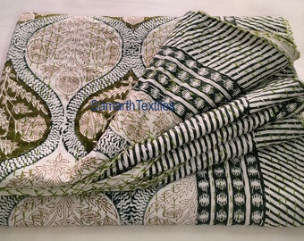 May include: A white cotton quilt with a black and green floral pattern. The quilt is folded in thirds and has a label that reads "Samarth Textiles".