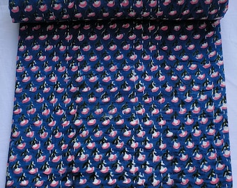 May include: A blue cotton fabric with a repeating pattern of pink flowers and green leaves. The fabric is folded and rolled up.