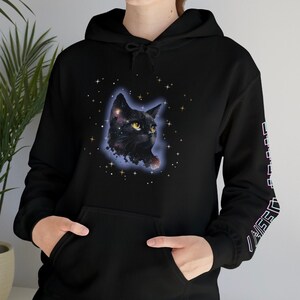 May include: Black hoodie with a graphic of a black cat in a galaxy with stars. The hoodie has a large pocket on the front and a small graphic on the sleeve.