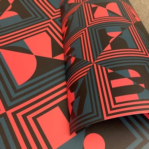 May include: A repeating pattern of geometric shapes in black, red, and blue. The pattern features squares, circles, and triangles.