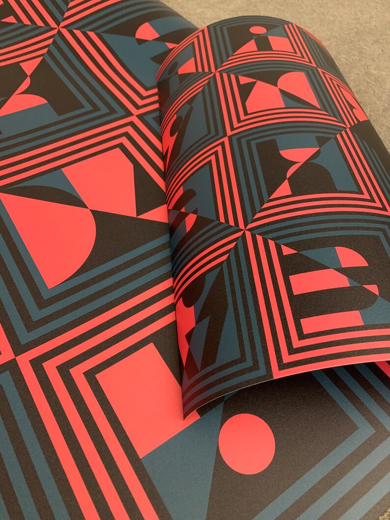 May include: A repeating pattern of geometric shapes in black, red, and blue. The pattern features squares, circles, and triangles.