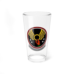 May include: A clear glass pint glass with a black, yellow, red, and white logo featuring a hand reaching for a ring with wings. The text "PROGRESS BY TEAMWORK" is printed below the logo.
