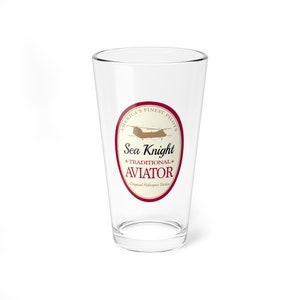 May include: A clear glass pint glass with a red and white label that says "America's Finest Pilots Sea Knight Traditional Aviator Original Helicopter Tactics". The label also features a small illustration of a helicopter.