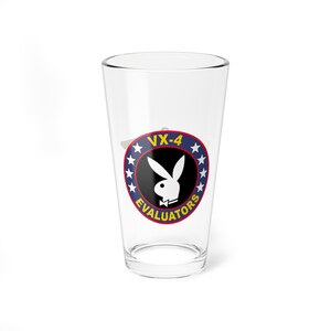 May include: A clear glass pint glass with a blue and yellow logo featuring a white rabbit with a bow tie and the text "VX-4 EVALUATORS".