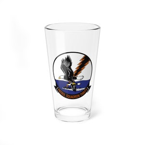 Könnte beinhalten: Ein klares Glas Pint-Glas mit einer marineblauen, weißen und orangefarbenen Grafik eines Weißkopfseeadlers, der über einem Gewässer fliegt. Der Text "PATROL SQUADRON THIRTY" ist unterhalb des Adlers aufgedruckt.