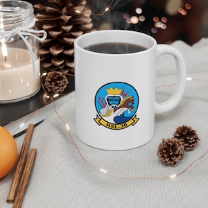 May include: White ceramic coffee mug with a blue, yellow, and red graphic of a sea god with a trident and a horse. The text "HSL-30" is printed below the graphic.