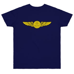 May include: A navy blue t-shirt with a yellow embroidered design of a pair of wings with an anchor and the letters "A.I.C." in the center.
