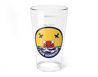 May include: A clear glass pint glass with a navy blue and yellow circle graphic. The graphic features two black airplanes flying over a red sun and blue waves. The text "2 SUN DOWNERS" is written in a white arc around the bottom of the circle.