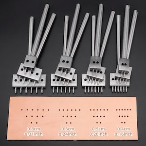 Könnte beinhalten: Eine Sammlung silberner Lederhandwerkzeuge, darunter Lochstanzen und ein Lederbeispiel mit vorgestanzten Löchern. Die Probe zeigt Lochgrößen von 0,8, 0,6, 0,5 und 0,4 cm. Die Werkzeuge sind auf einer dunklen Oberfläche angeordnet.