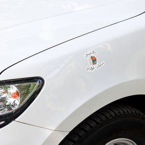 Op de afbeelding: Witte auto met een sticker aan de zijkant met de tekst "Sterker dan Multiple Sclerose" met een hersengrafiek met bloemen.