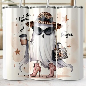 May include: A white tumbler featuring a cartoon ghost in a leopard print hat and sunglasses, holding a coffee cup and a purse. The text reads "I put the boo... in boujee."